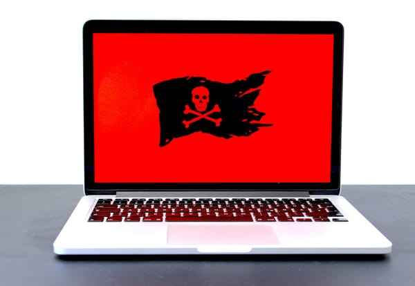 A laptop displays a black and red pirate flag